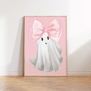 Pu&ograve; includere: Un fantasma rosa e bianco con un grande fiocco rosa sulla testa. Il fantasma ha due occhi neri e una piccola bocca. Lo sfondo &egrave; di colore rosa chiaro.