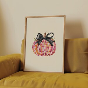 May include: A watercolor painting of a pink and orange mosaic pumpkin with a black bow. The pumpkin is sitting on a white background.