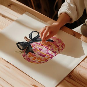 May include: A watercolor painting of a pink and orange pumpkin with a black bow. The pumpkin is painted in a mosaic style.