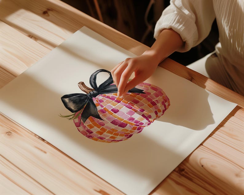 May include: A watercolor painting of a pink and orange pumpkin with a black bow. The pumpkin is painted in a mosaic style.