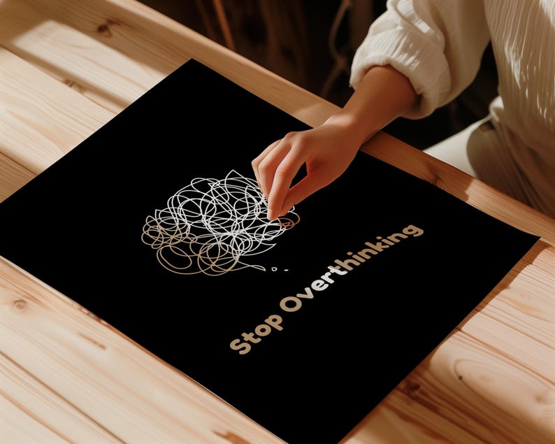Pu&ograve; includere: Un poster nero con un disegno di scarabocchi bianchi e il testo "Stop Overthinking" in lettere bianche.