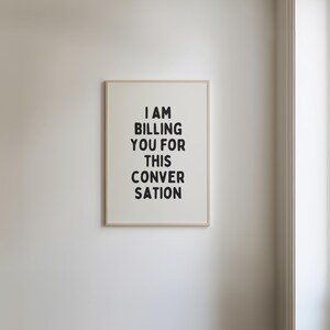 May include: A framed print with the text "I AM BILLING YOU FOR THIS CONVERSATION" in black lettering on a white background.