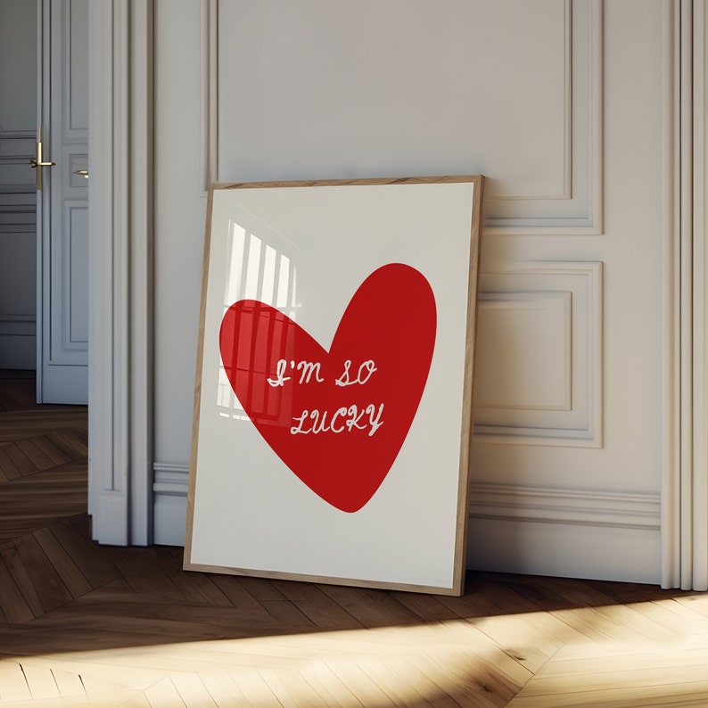May include: A white framed print with a red heart shape and the text "I'm so lucky" in white.
