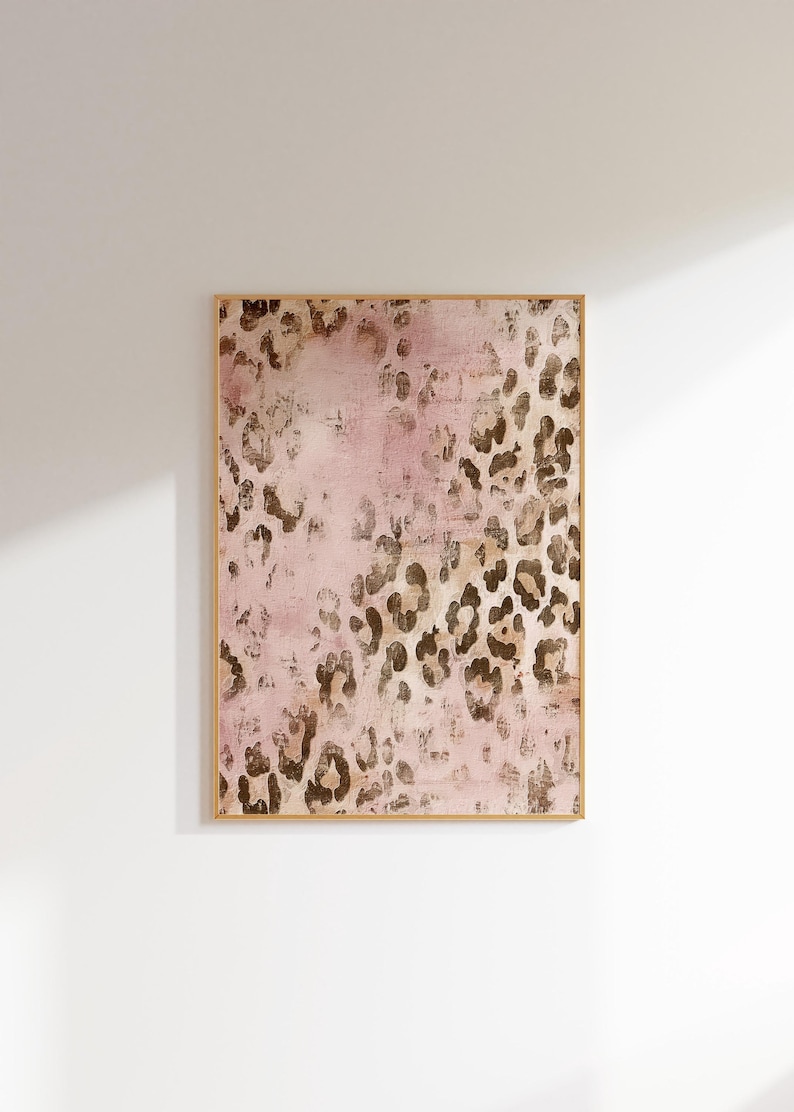 May include: A framed abstract art print with a pink background and a brown leopard print pattern.