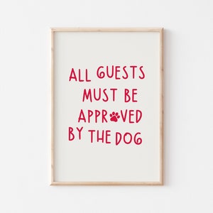 Puede incluir: Una impresi&oacute;n enmarcada con el texto "ALL GUESTS MUST BE APPROVED BY THE DOG" en letras rojas con una huella de pata en la palabra "APPROVED".