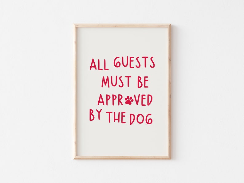 Puede incluir: Una impresi&oacute;n enmarcada con el texto "ALL GUESTS MUST BE APPROVED BY THE DOG" en letras rojas con una huella de pata en la palabra "APPROVED".