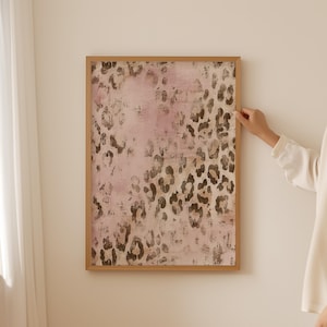 May include: A framed print featuring an abstract leopard print design in shades of pink and brown.