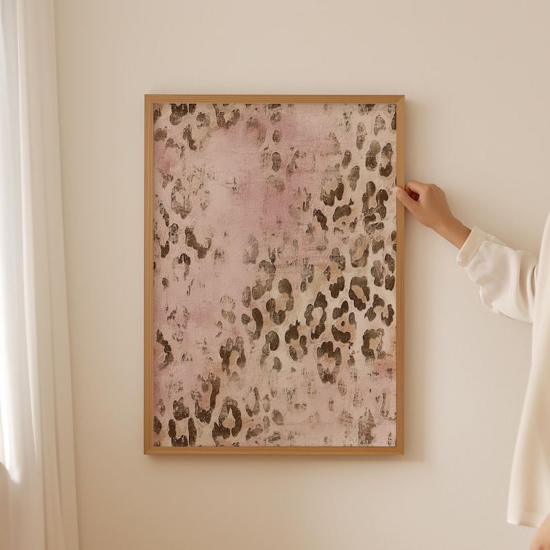 May include: A framed print featuring an abstract leopard print design in shades of pink and brown.