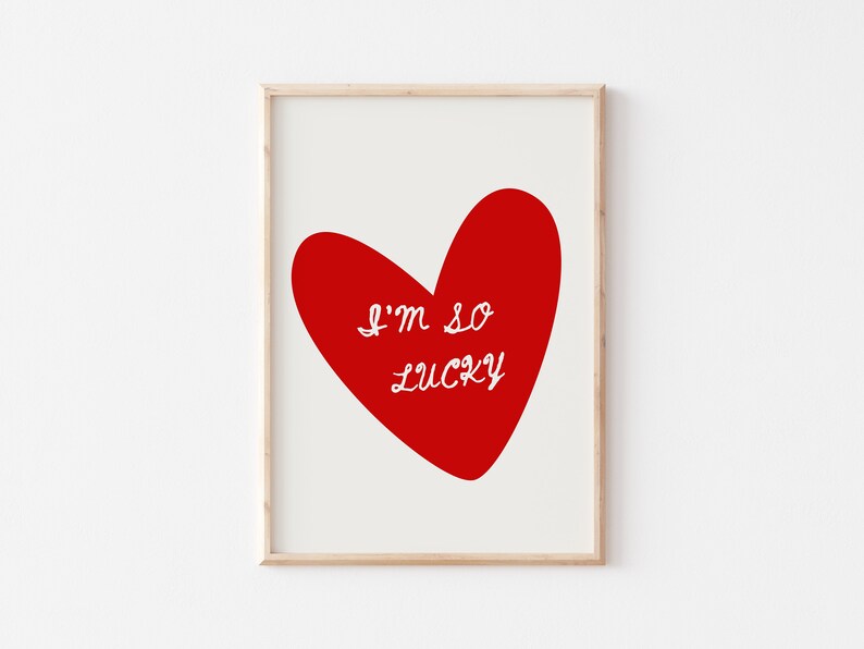 May include: A framed print with a red heart and the text "I'm so lucky" in white.