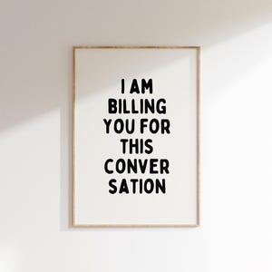 May include: A framed print with the text "I AM BILLING YOU FOR THIS CONVERSATION" in black bold letters on a white background.