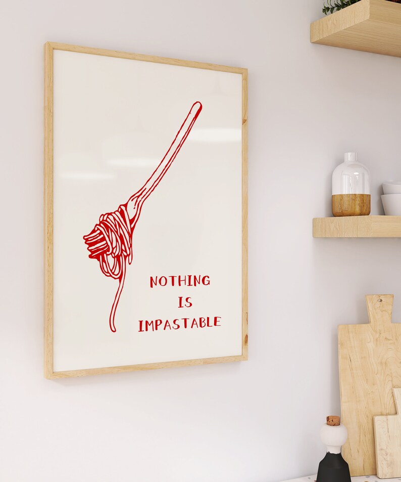 May include: A white framed print with a red illustration of a fork with spaghetti on it. The text "NOTHING IS IMPASTABLE" is written in red below the illustration.