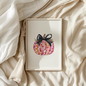 May include: A framed watercolor painting of a pink and orange pumpkin with a black bow. The pumpkin is decorated with a mosaic pattern.