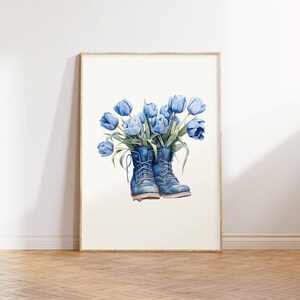 K&ouml;nnte beinhalten: Ein Aquarellbild von einem Paar blauer Arbeitsschuhe mit einem Strau&szlig; blauer Tulpen, die aus den Oberteilen wachsen.