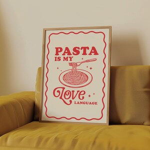 May include: A white poster with a red border and red text that says "Pasta is my love language." The poster features a drawing of a plate of spaghetti with a fork in it.