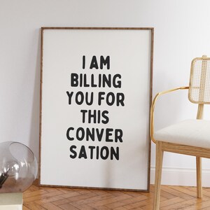 May include: A framed print with the text "I AM BILLING YOU FOR THIS CONVERSATION" in black lettering on a white background.