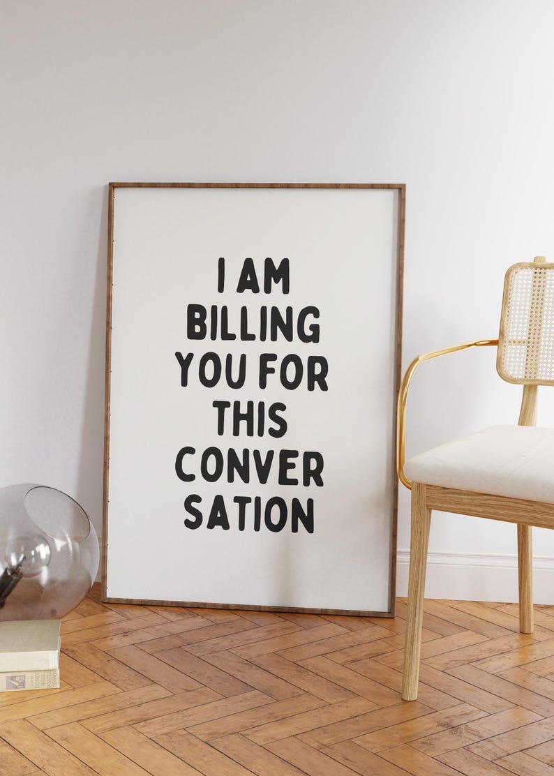 May include: A framed print with the text "I AM BILLING YOU FOR THIS CONVERSATION" in black lettering on a white background.