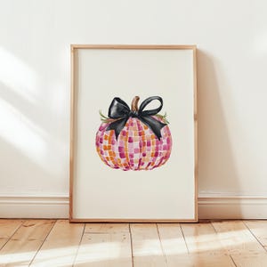 May include: A watercolor painting of a pink and orange checkered pumpkin with a black bow. The pumpkin is sitting on a white background.