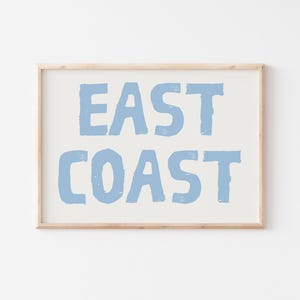 May include: A framed print with the text "EAST COAST" in a light blue color on a white background.
