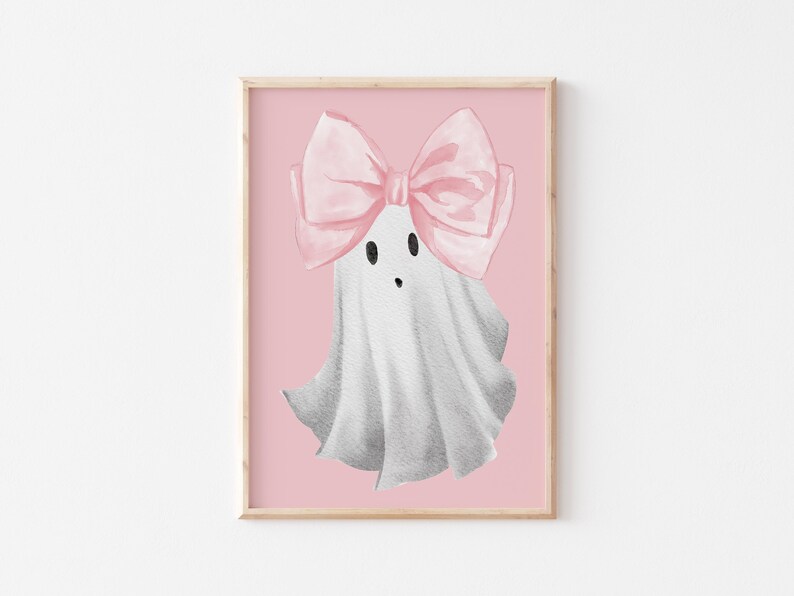 Pu&ograve; includere: Un fantasma bianco con un fiocco rosa sulla testa. Il fantasma ha un viso carino da cartone animato con due occhi neri e una piccola bocca. Lo sfondo &egrave; di colore rosa chiaro.