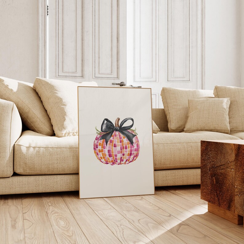 May include: A watercolor painting of a pink and orange pumpkin with a black bow. The pumpkin is on a white background.