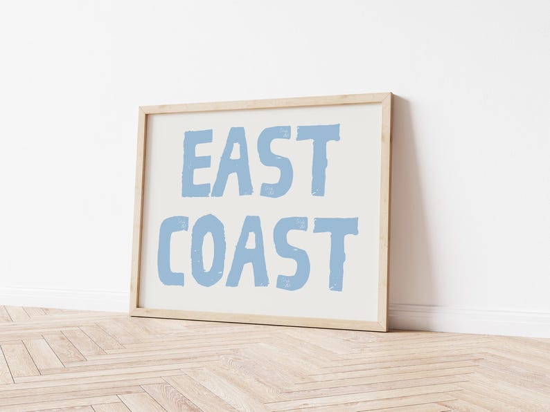 May include: A framed print with the text "EAST COAST" in a light blue color on a white background.