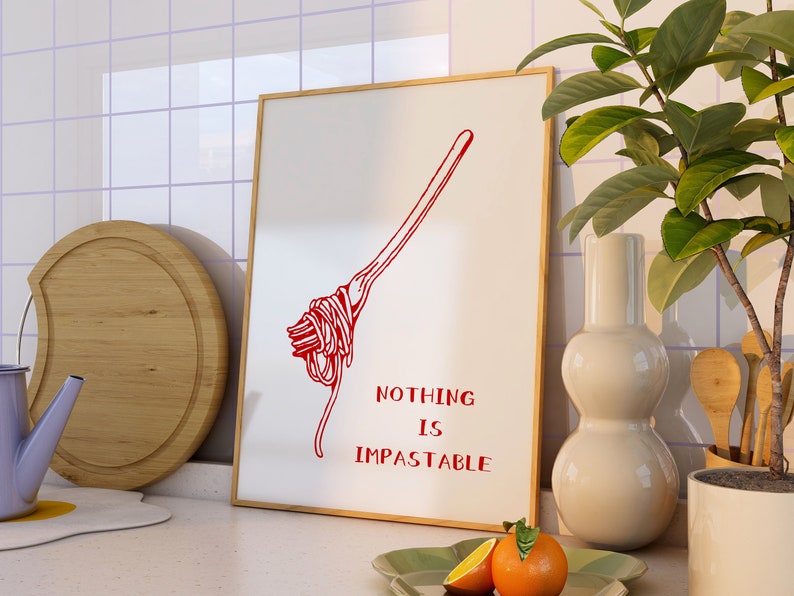 May include: A white framed print with a red illustration of a fork with spaghetti on it. The text "NOTHING IS IMPASTABLE" is written below the illustration.