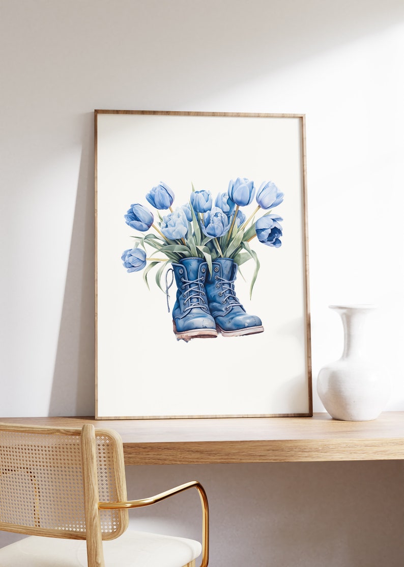 K&ouml;nnte beinhalten: Ein gerahmtes Aquarellbild von blauen Tulpen in einem Paar blauer Stiefel. Die Stiefel sind mit Schn&uuml;rsenkeln gebunden und die Tulpen sind zu einem Strau&szlig; angeordnet.