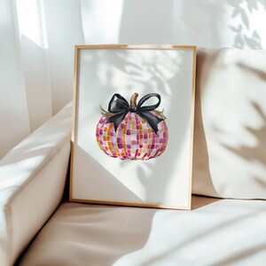 May include: A framed watercolor painting of a pink and orange mosaic pumpkin with a black bow. The pumpkin is sitting on a white background.