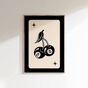 Op de afbeelding: Zwart-witte illustratie van twee kersen met het nummer 8 op elk, met een enkele ster erboven op een beige achtergrond.