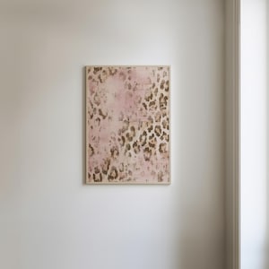 May include: A framed canvas print featuring an abstract leopard print design in shades of pink and brown.