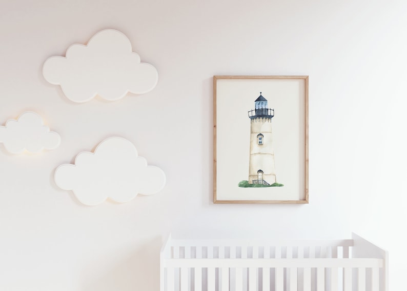 May include: A watercolor painting of a white lighthouse with a black roof and a blue window. The lighthouse is surrounded by green grass and is set against a white background. The painting is framed in a light wood frame.