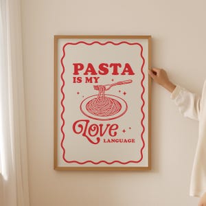 May include: A white poster with a red border and red text that says "PASTA IS MY LOVE LANGUAGE". The poster features a red illustration of a plate of spaghetti with a fork.