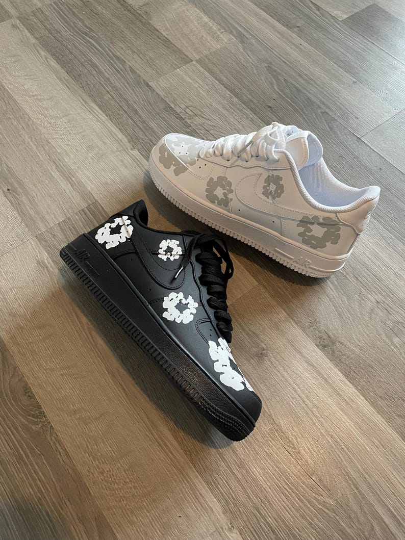 May include: A pair of white and black sneakers with a floral pattern. The sneakers are low-top and have a white sole.