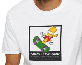 May include: White t-shirt featuring a cartoon image of a yellow character skateboarding. The image is framed in black and has the text "COWABUNGA DUDE" below it. The text below the image reads "AN EXPRESSION OF EXCITEMENT, ENTHUSIASM, OR TRIUMPH. IT'S A PLAYFUL, REBELLIOUS CATCHPHRASE POPULARIZED IN THE 80'S AND 90'S."