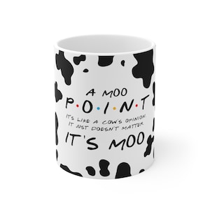 Peut inclure: Une tasse en céramique blanche avec un motif imprimé vache noir et blanc. La tasse porte le texte "A MOO POINT. IT'S LIKE A COW'S OPINION. IT JUST DOESN'T MATTER. IT'S MOO" en noir.
