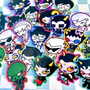 May include: A white ceramic mug with a black handle and the text "But First, Coffee" in a black, handwritten-style font. The mug is on a white surface.