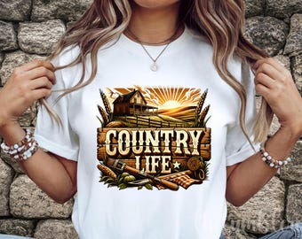 May include: White t-shirt featuring a colorful graphic with the words "COUNTRY LIFE" in a rustic font. The design includes a farmhouse, wheat, and tools, evoking a rural theme. The shirt is made of a soft material.