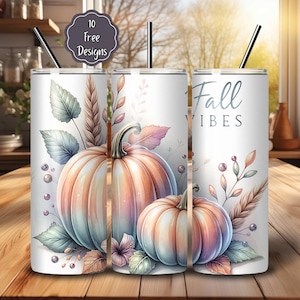 Puede incluir: Vaso blanco con temática otoñal, con calabazas de acuarela en tonos naranja, melocotón y azul. El diseño incluye hojas y el texto "Fall Vibes". Cada vaso tiene una pajita negra y una tapa. La imagen también incluye una etiqueta que dice "10 Free Designs".