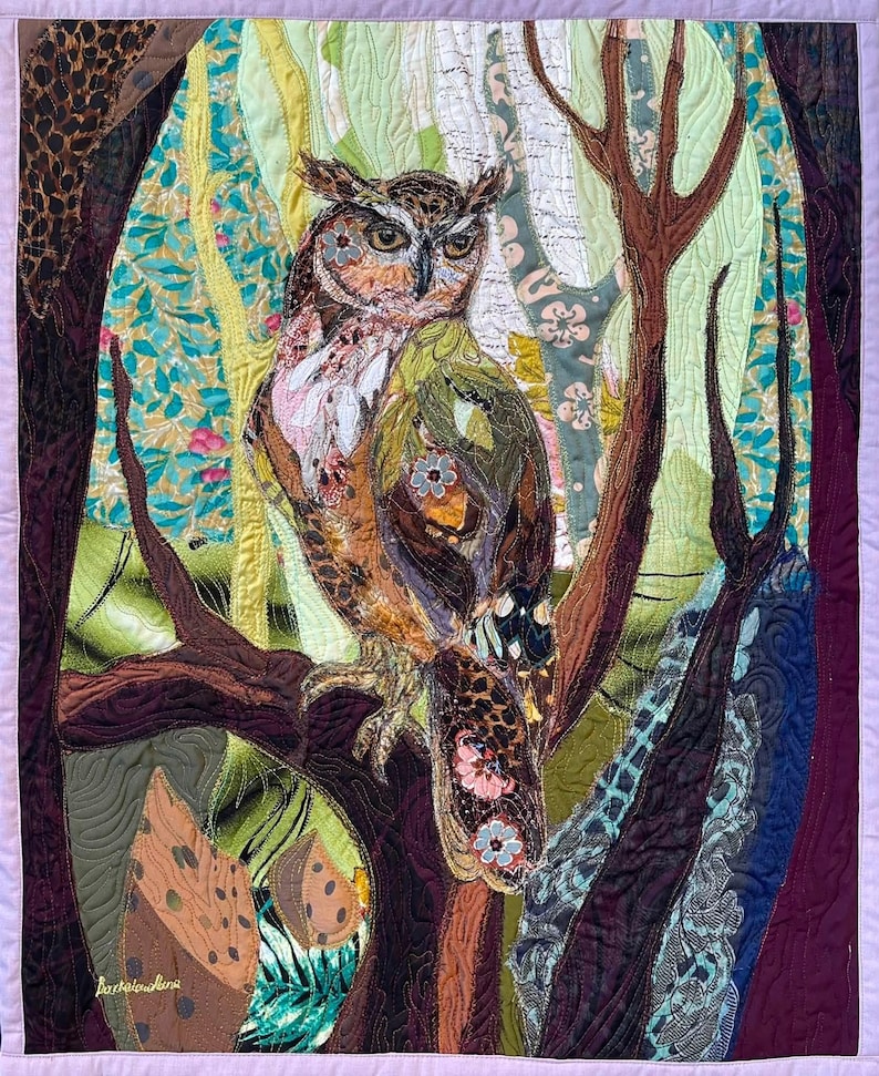 Original textile art quilt featuring a majestic owl perched among forest trees with richly layered fabrics and intricate quilting, 62 × 50 cm.