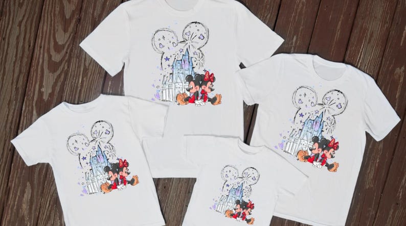 May include: Five white t-shirts with a Disney theme. Each shirt features a graphic of Mickey and Minnie Mouse in front of a castle, with a Mickey Mouse head outline above. The graphic includes purple and blue accents.