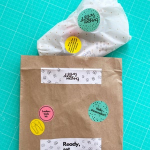 May include: A brown paper bag with various stickers on it. The stickers include the words "Easy Shoe Making", "Loafers Tools Kit", "Hello Shoemaker!" and "Ready, Set, Shoes!"