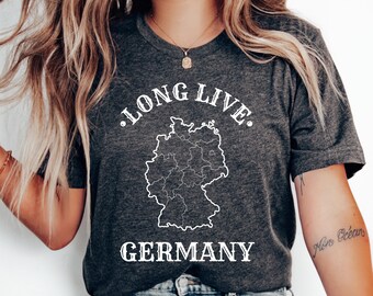 Puede incluir: Camiseta gris oscuro con las palabras "LONG LIVE" sobre un contorno blanco del mapa alemán y la palabra "GERMANY" debajo. La camiseta está hecha de un material suave.