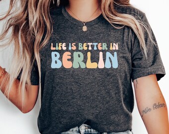 May include: A dark gray t-shirt with the text "Life is better in Berlin" in colorful, stylized letters.