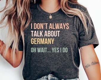 Puede incluir: Una camiseta gris oscuro con el texto "No siempre hablo de Alemania. Oh, espera... Sí, lo hago." impreso en un degradado arcoíris.