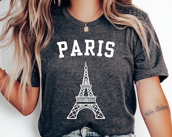 Op de afbeelding: Een donkergrijs T-shirt met een witte afbeelding van de Eiffeltoren en het woord "PARIS" in witte blokletters.