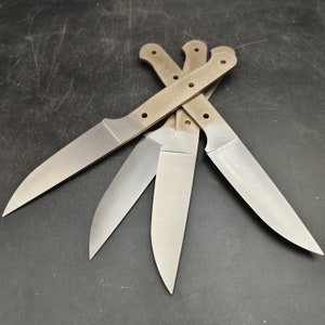 Könnte beinhalten: Vier unfertige Messerklingen mit braunen Griffen. Die Klingen sind sternförmig angeordnet.