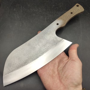May include: A large, silver chef's knife with a brown wooden handle. The knife has a slightly curved blade and a rounded tip.