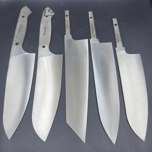 Könnte beinhalten: Fünf silberne Küchenmesser mit verschiedenen Klingenformen und -größen. Die Messer liegen auf einer dunkelgrauen Oberfläche.