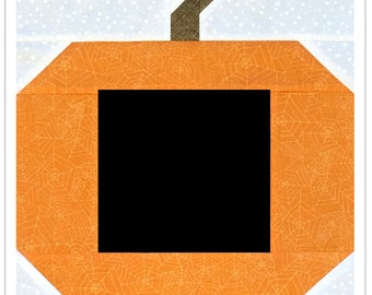 Puede incluir: Calabaza naranja con un cuadrado negro en el centro y un tallo marrón en la parte superior. La calabaza tiene un patrón de telaraña.