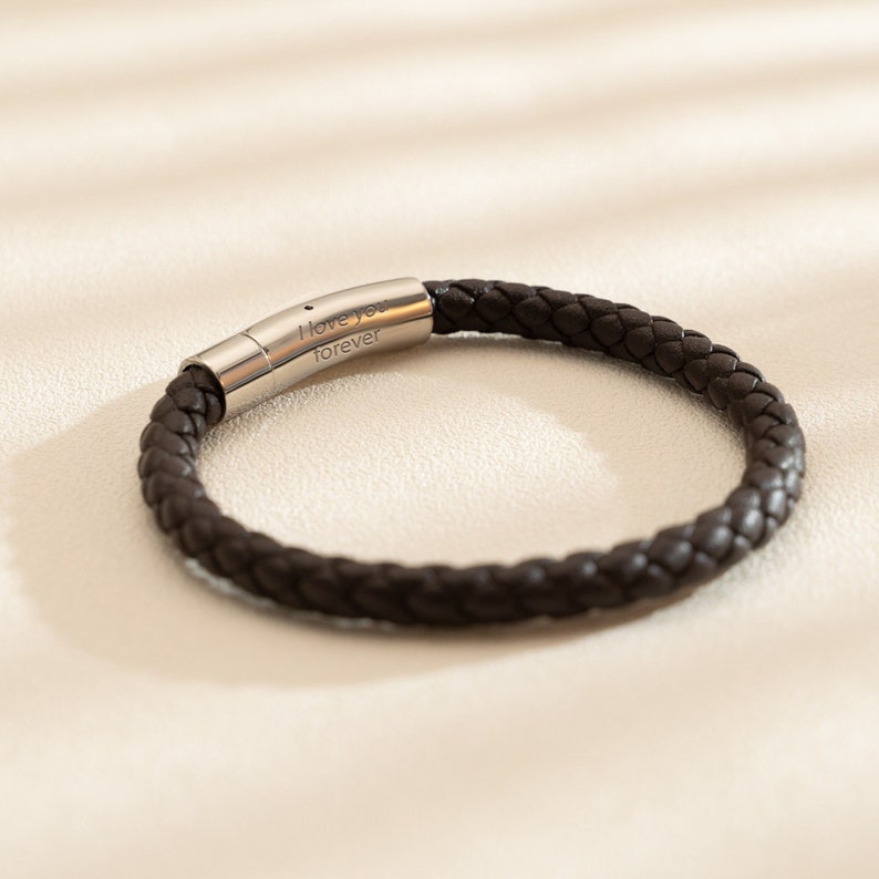 May include: A brown leather bracelet with a silver clasp engraved with the words "I love you forever".
